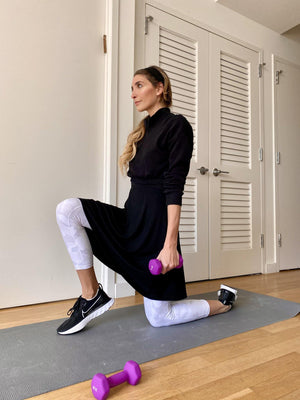 Mia Mod Sway Skirt styled with a black long sleeved blouse, white leggings, and black Nike sneakers